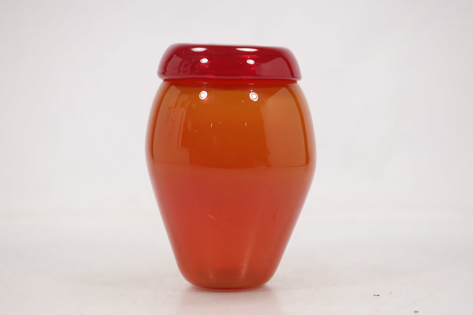 Orange and Red Cased Art Glass Vase: Photographs show orange and red cased art glass vase with the color profile surface treatment and molded or applied decoration visible from multiple angles. No maker is assigned unless supported by a 