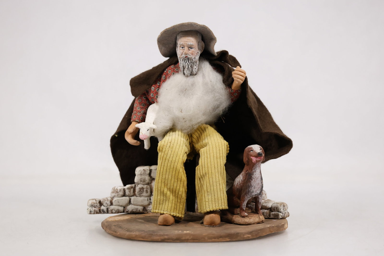 Ceramic Seated Elderly Man Figurine: Photographs show ceramic seated elderly man figurine in glazed ceramic or pottery with the visible form color and decorative motifs described directly from the images. No unverified maker or date is a