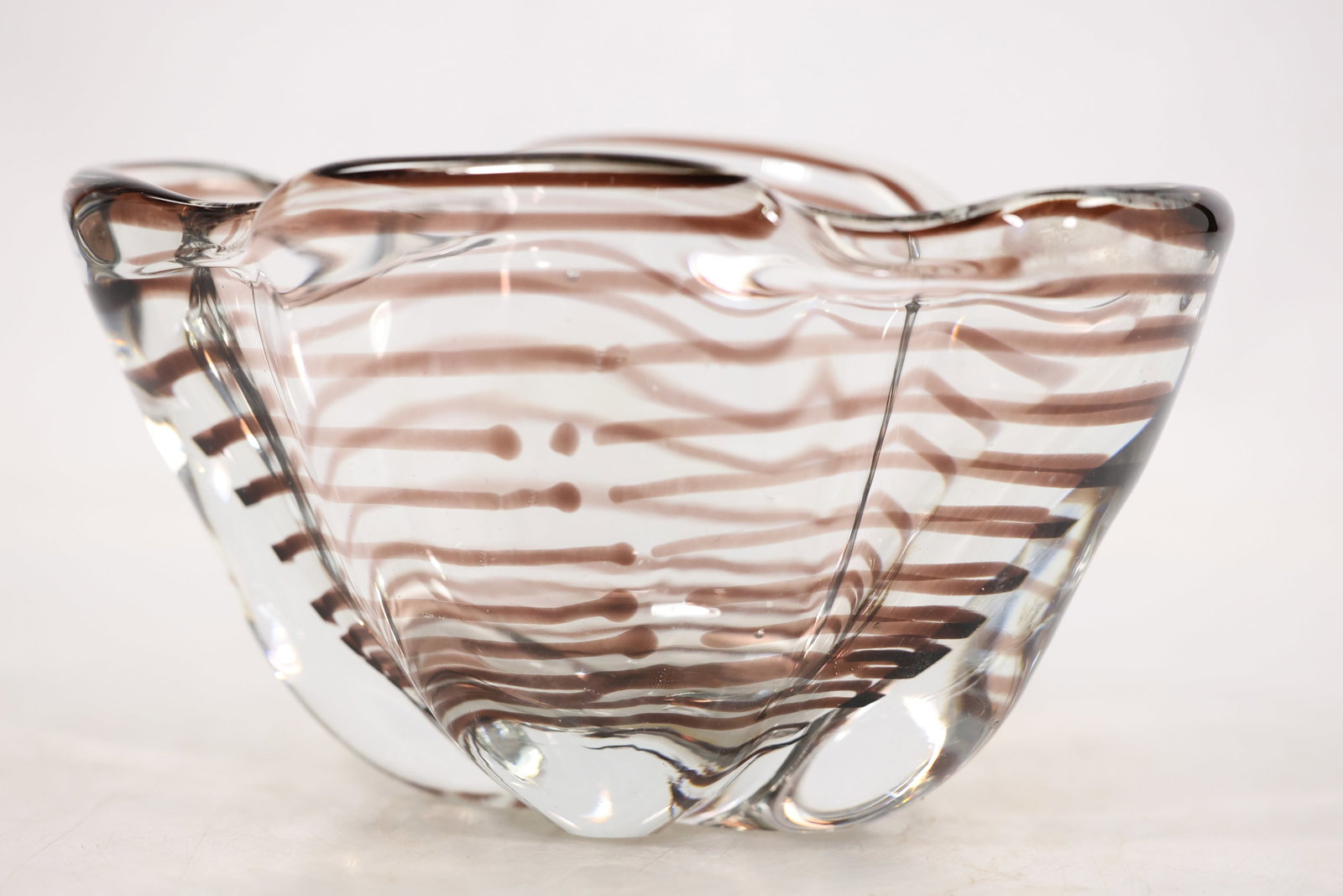 Clear Applied Spiral Art Glass Bowl: A clear art glass bowl has a rounded basin wrapped by an applied spiral glass trail. The transparent body and continuous raised coil create a sculptural vessel form and no maker is confirmed. Its scul