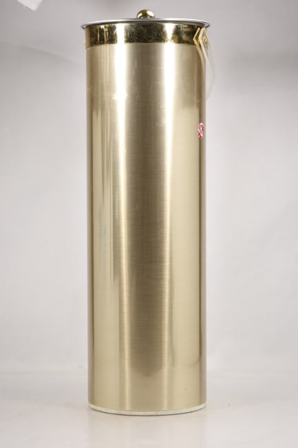 Tall Brass Tone Cylindrical Ice Bucket with Lid: A tall cylindrical ice bucket is finished in brass tone metal with a fitted lid and carrying handle. The insulated serving form straight sides and coordinated hardware identify it as vintage barware a