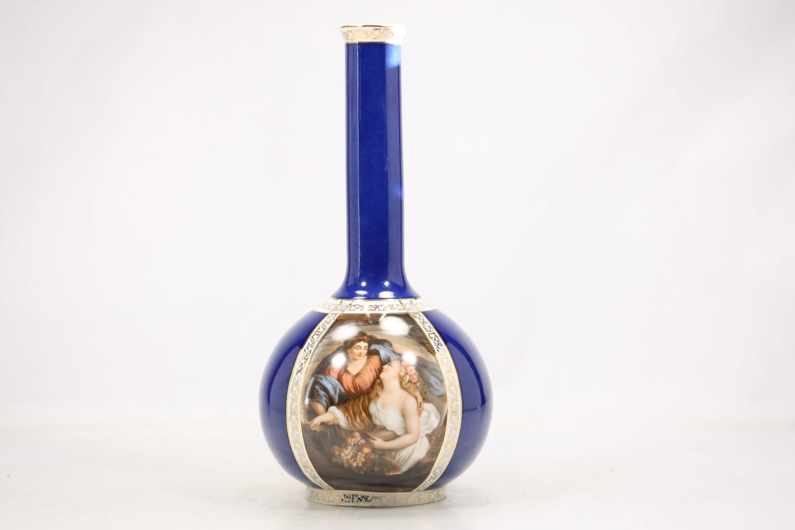 Blue Glass Bottle Vase with Silver Overlay Figure: A tall blue glass bottle vase has a narrow neck rounded shoulder and silver tone overlay depicting a human figure with ornamental bands. The contrasting overlay and saturated translucent body create