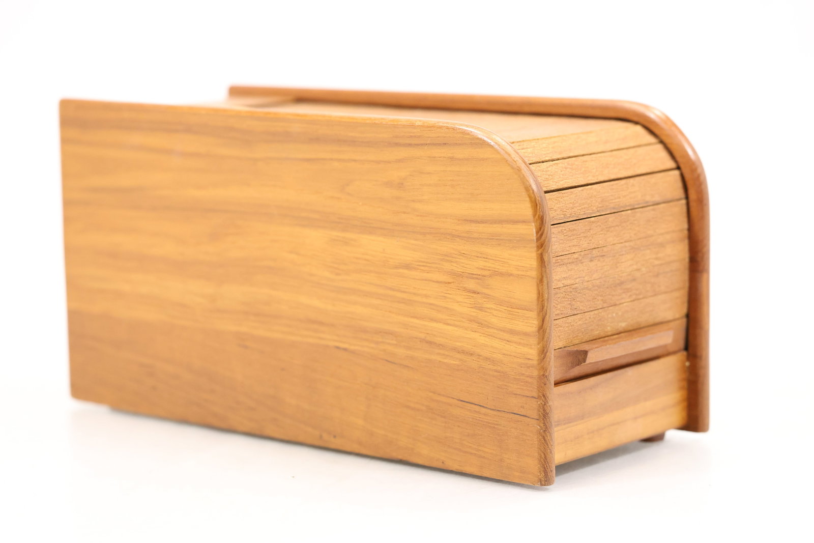 Roll Top Wood Bread Box: A wood bread box has a rectangular case with a sliding roll top front and visible natural grain. The tambour closure and countertop storage format identify the object as kitchenware and no maker is