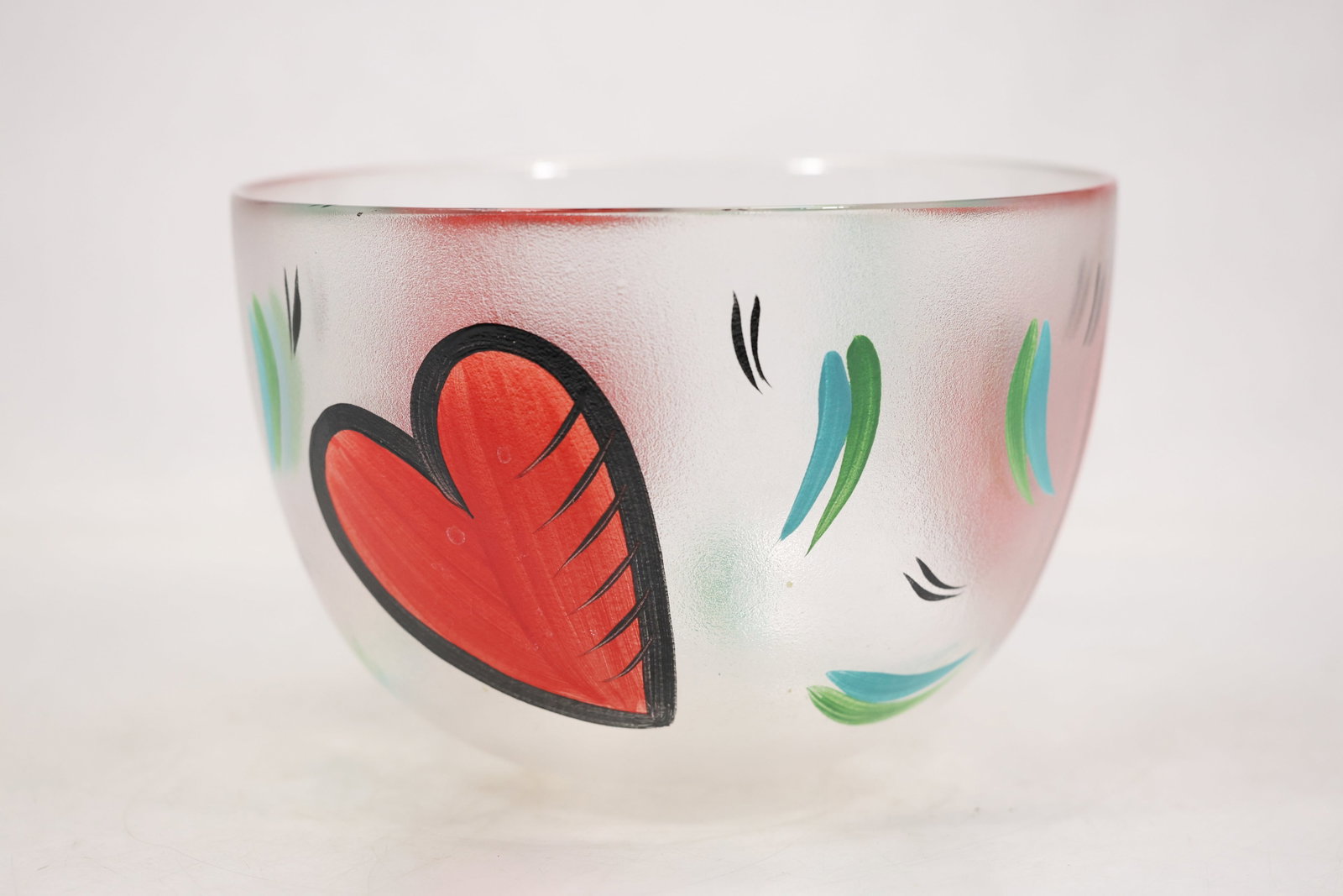 Kosta Boda Hearts Glass Bowl by Ulrica Hydman Vallien: Swedish art glass bowl from the Hearts series designed by Ulrica Hydman Vallien for Kosta Boda. The rounded clear glass form has a frosted textured surface hand painted with large red hearts outlined 