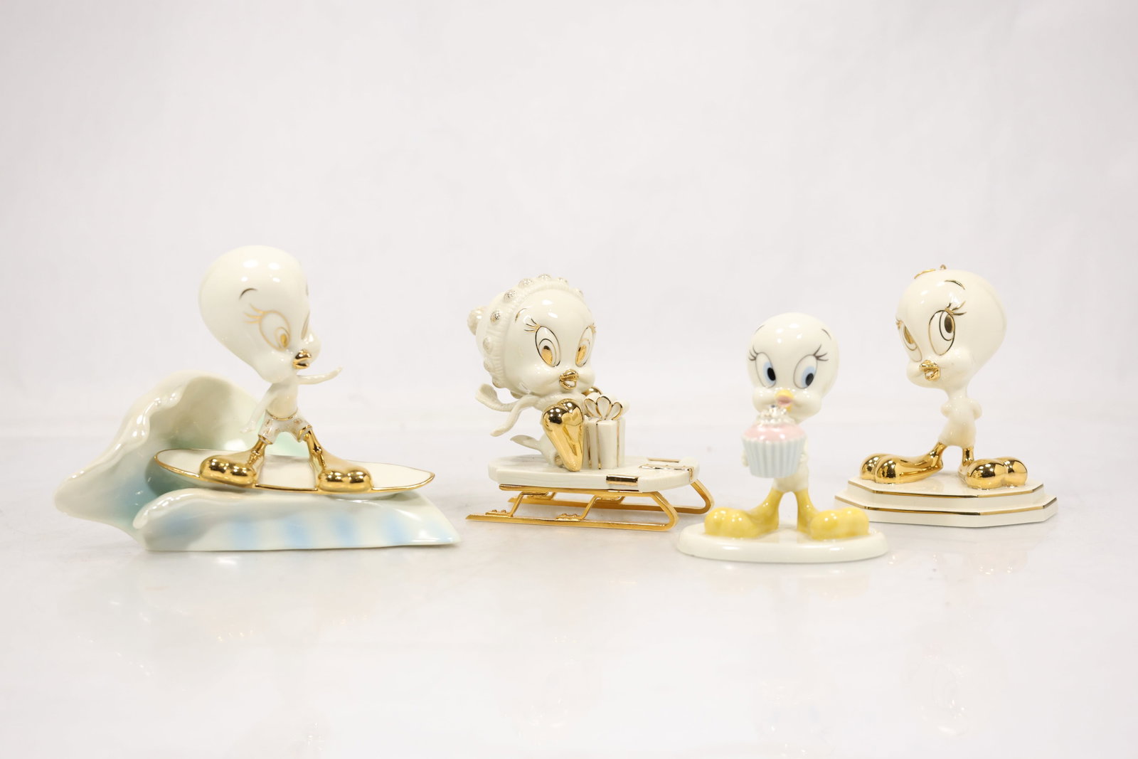 Four Tweety Bird Ceramic Character Figurines: A group of four ceramic figurines depicts the animated character Tweety Bird in varied poses. The yellow character coloring molded cartoon features and coordinated scale identify the group while no ma