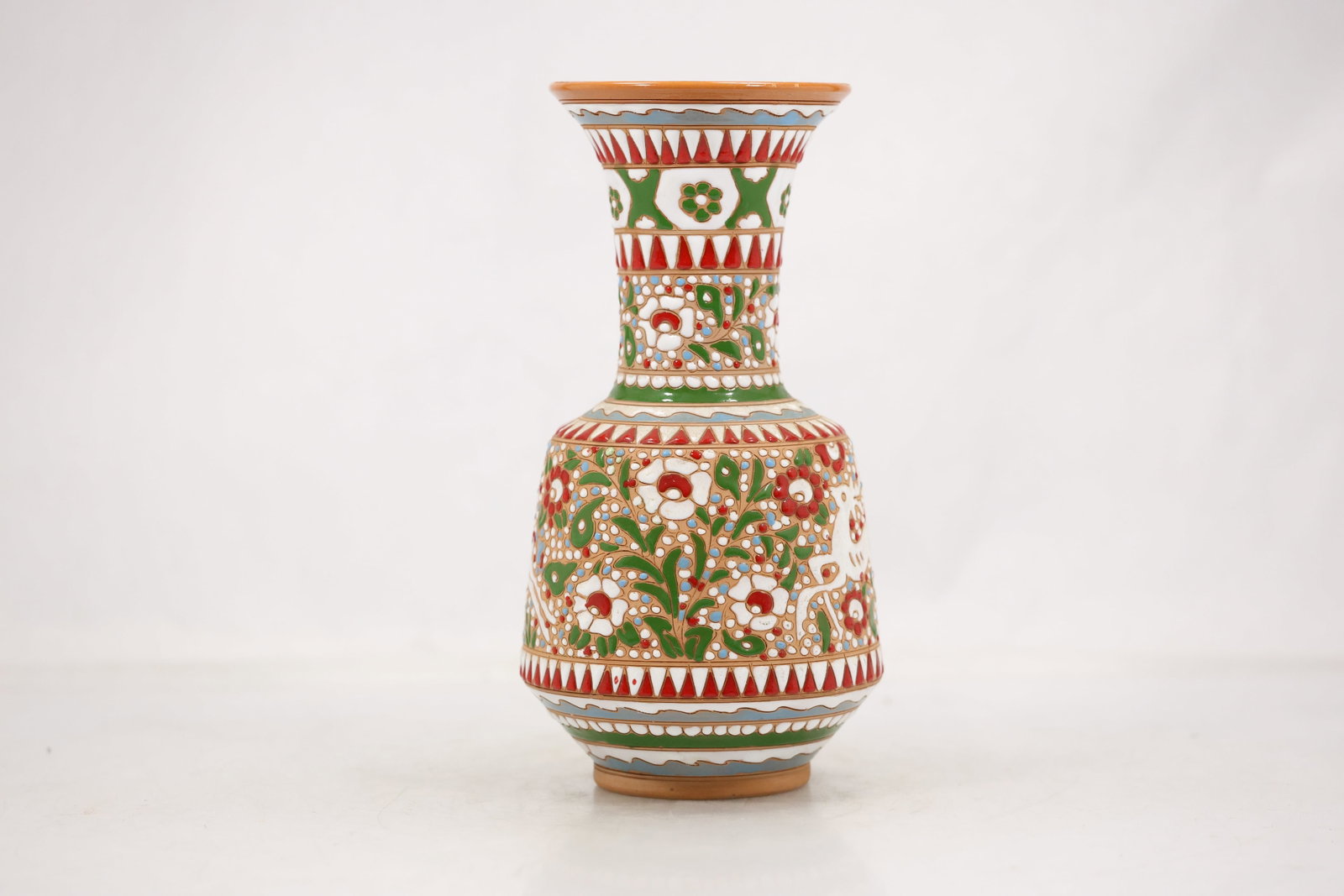 Multicolor Geometric Decorated Pottery Vase: A pottery vase has a rounded body covered in multicolor geometric shapes and linear decoration. The hand decorated surface and strong graphic pattern create a postmodern decorative profile and no