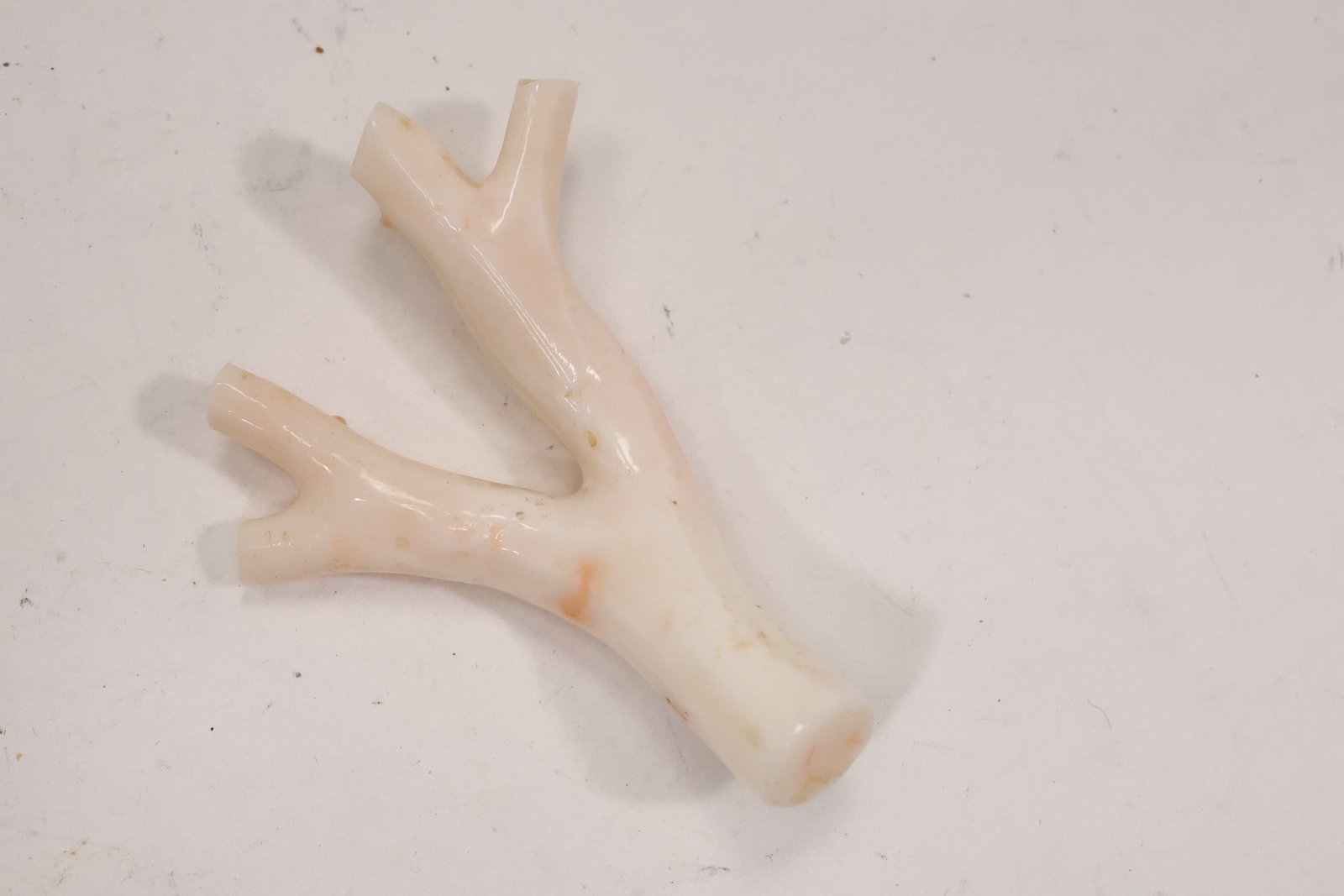 Angel Skin Coral Branch Pin with 14K Gold Clasp: A natural branch form angel skin coral pin is fitted with a 14K gold clasp. The pale coral color organic branching structure and pin mechanism identify it as figural natural material jewelry and the
