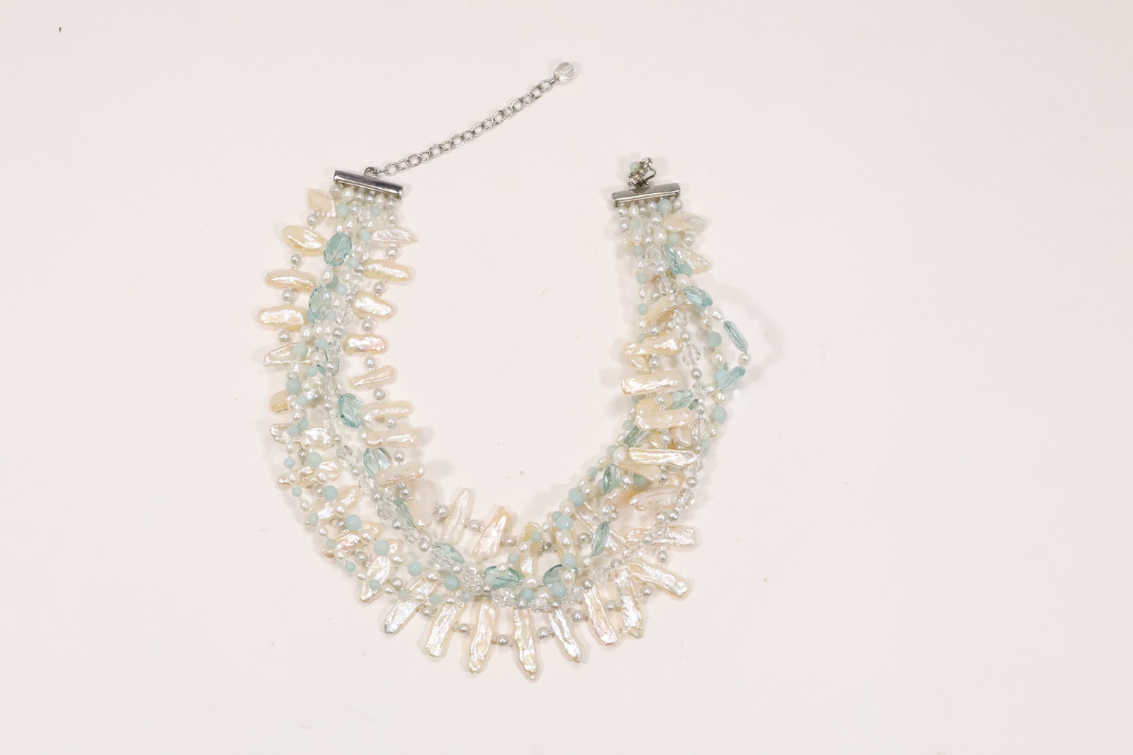 Six Strand Freshwater Pearl Jade and Glass Bead Necklace: A six strand necklace combines cultured freshwater pearls with clear glass beads and green jade beads. The multiple draped strands create a wide collar format with varied translucent and lustrous surf
