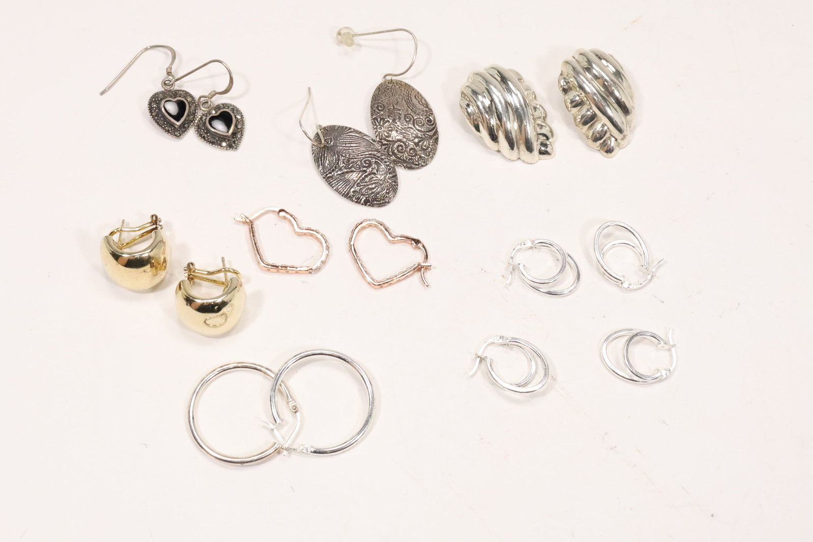 Sterling Silver Pierced and Clip Earring Group: An assorted sterling silver earring group includes pierced and clip formats with floral geometric and abstract motifs. The mixed estate selection totals 30.4 grams according to the original catalog no