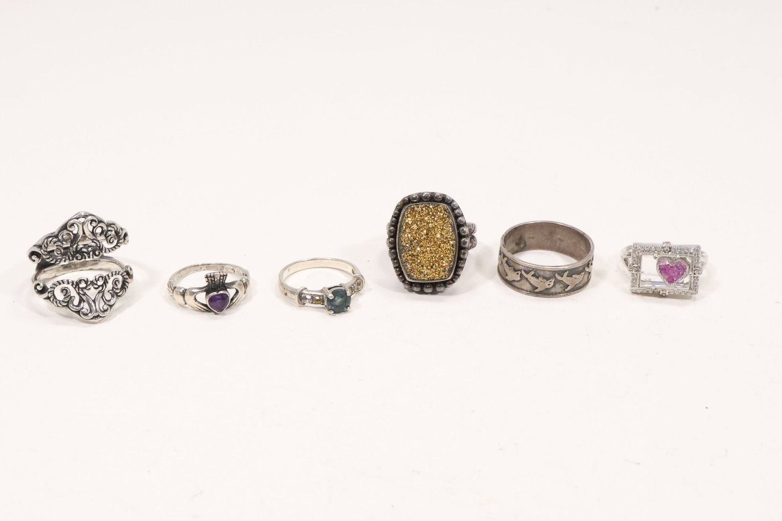 Six Sterling Silver Gemstone and Figural Rings: A six ring sterling silver group includes aquamarine purple spinel heart framed geode shark motif and abstract insert designs. The mixed estate group totals 41.9 grams according to the original catalo
