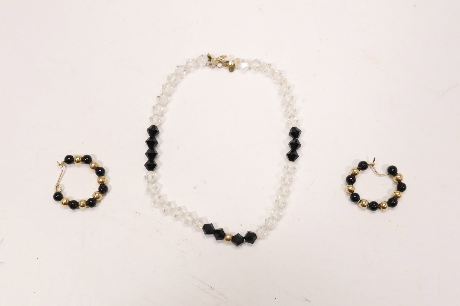 14K Gold Onyx Hoop Earrings and Glass Bead Bracelet: A jewelry group includes 14K gold hoop earrings set with black onyx and gold beads plus a glass bead bracelet with 14K gold components. The black and gold palette links the coordinated accessories. Th
