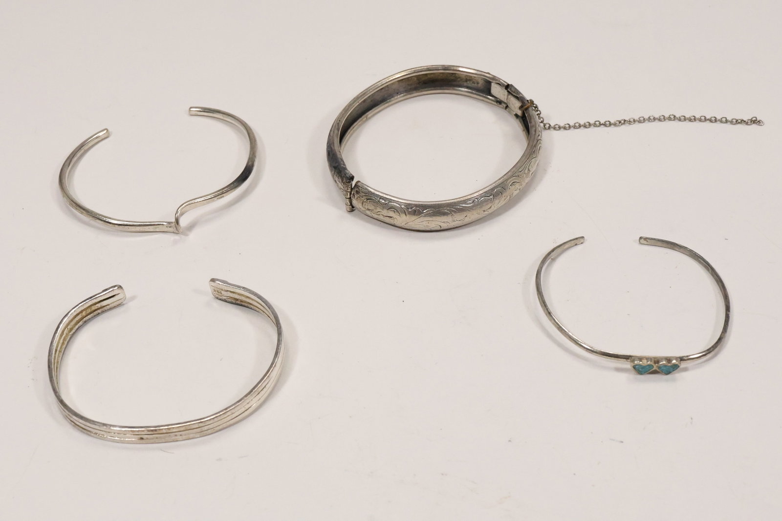 Carolyn Pollack and Sterling Silver Cuff Bracelet Group: A four piece sterling silver cuff and bangle group includes a Carolyn Pollack pinched cuff a three band cuff a turquoise set cuff and an etched bangle. The documented maker name applies only to the
