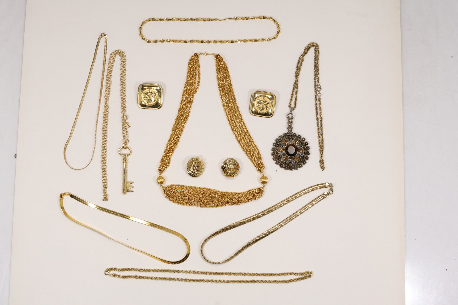 Gold Tone Designer and Costume Necklace Group: A costume jewelry group includes eight heavy gold tone necklaces an 18K plated nugget chain Deidre Hall key jewelry and signed Ciner and Dubin earrings. Maker names apply only to the cataloged signed 