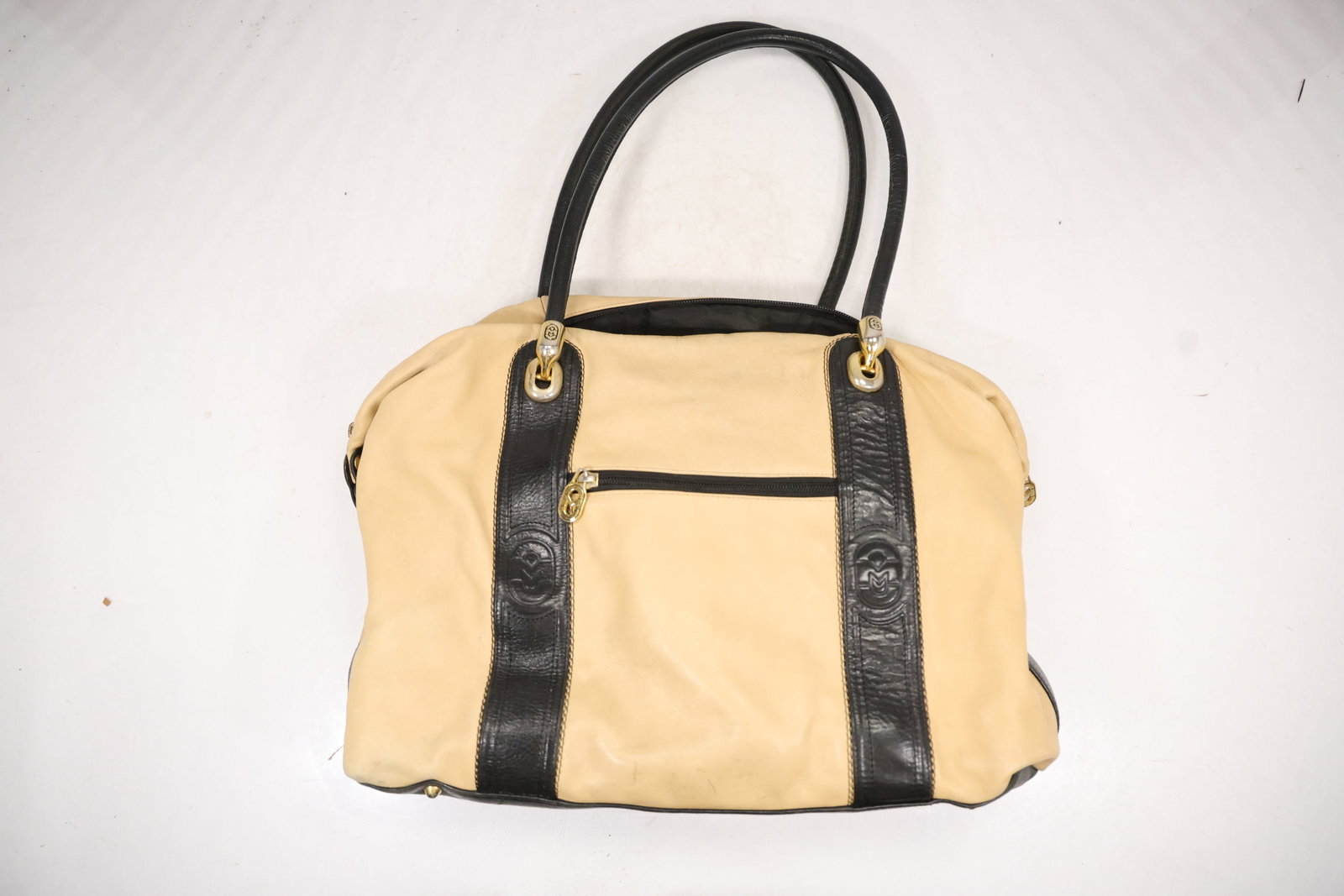 Cream Woven and Black Leather Structured Handbag: A structured handbag combines a cream woven body with black leather vertical trim rolled handles and a dark base. No legible interior brand label is confirmed in the photographs. The handbag construct
