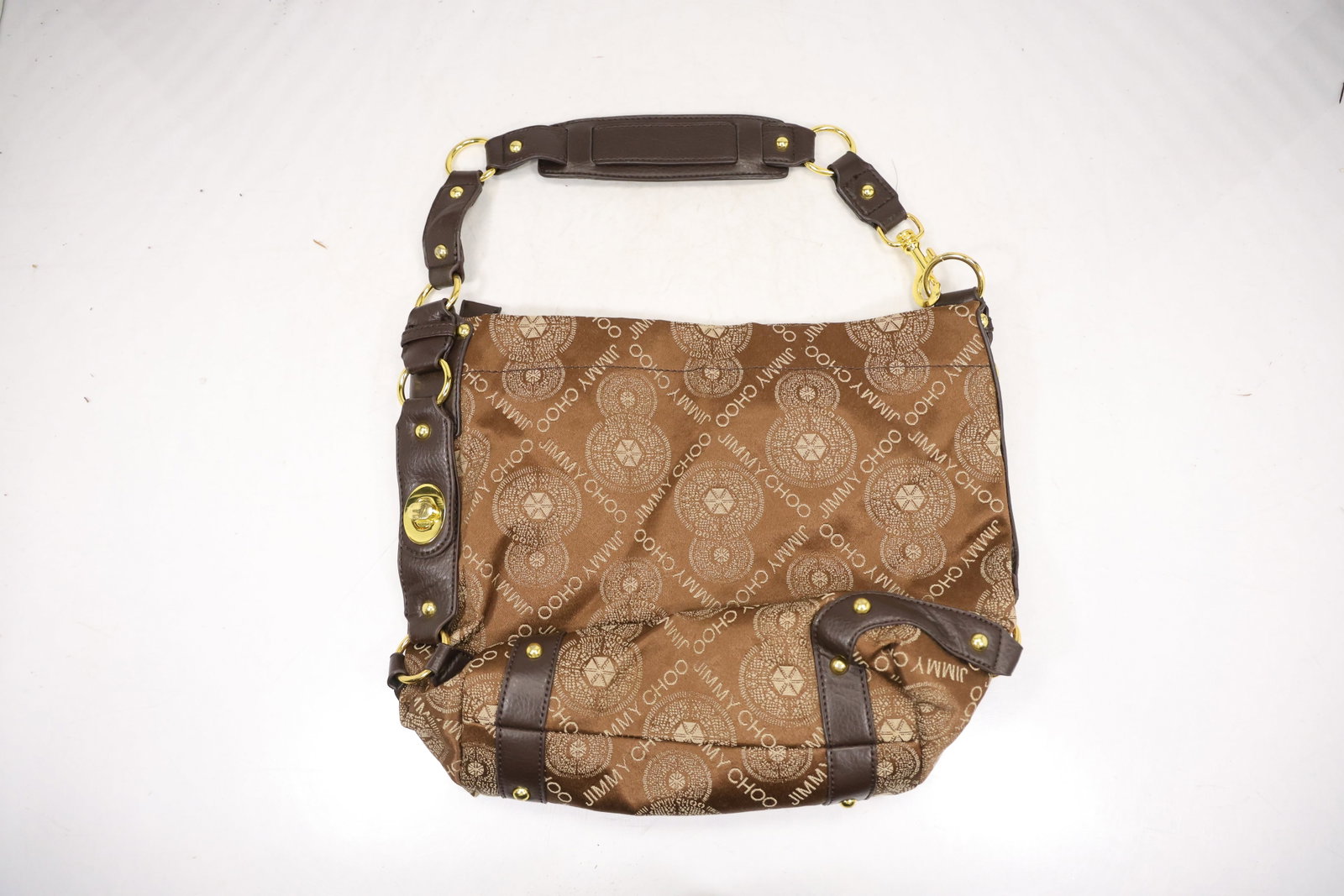 Gherardini Monogram Hobo Shoulder Bag: A brown Gherardini style hobo bag has a repeating monogram body dark leather handle gold tone circular hardware and a softly draped silhouette. The exact monogram pattern handle construction and match