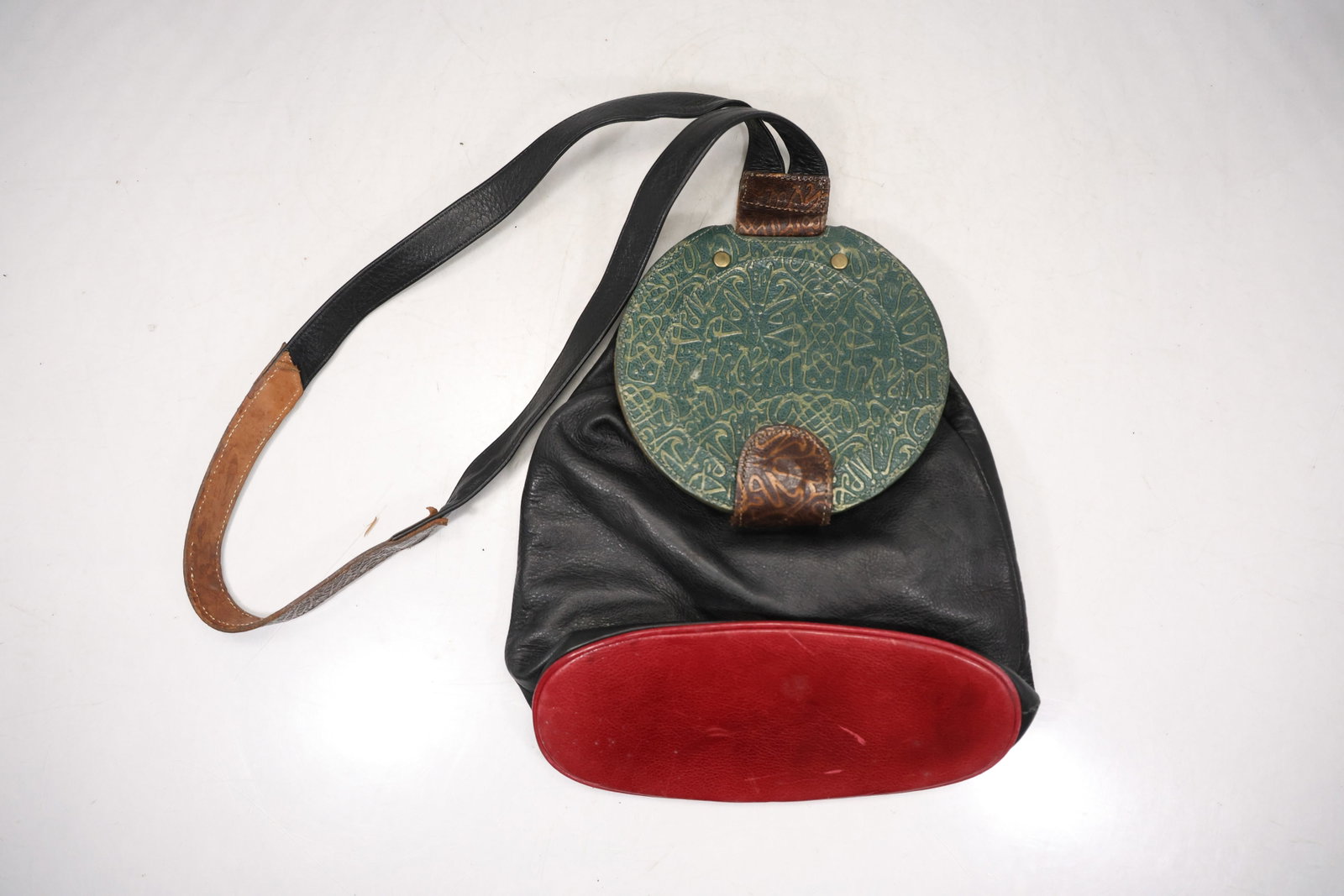 Two Vintage Color Block and Black Shoulder Bags: A two bag group includes a green and red color block shoulder bag with circular flap detail and a separate black gathered shoulder bag. No legible maker branding is confirmed in the photographs. The h