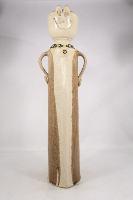Carved Figural Wood Ceremonial Staff or Scepter: A long carved wood staff or scepter has an ivory color smiling figural head finial a metal collar and a decorated shaft. The object is described as a ceremonial or decorative staff because the