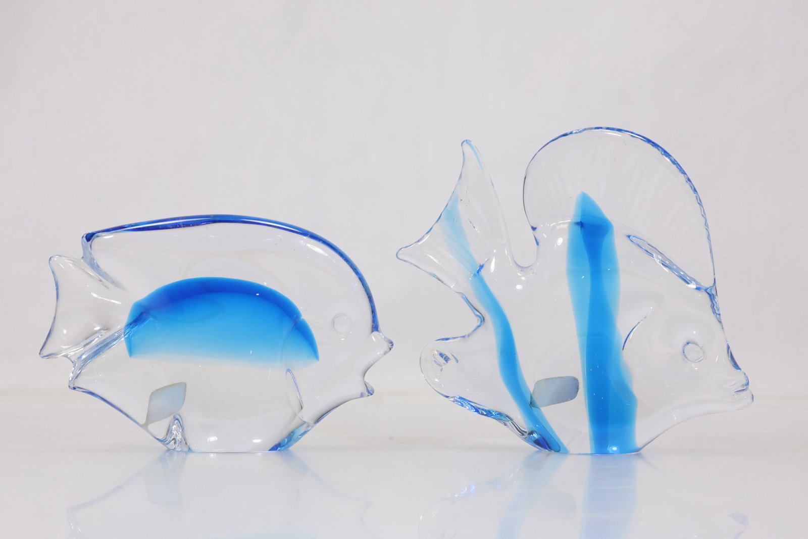 Marcolin Italian Blue Art Glass Fish Sculpture: Hand formed blue and clear art glass fish sculpture with sweeping fins elongated body and applied details. An underside label reads Marcolin Art Crystal and Genuine Hand Made in Italy. The form