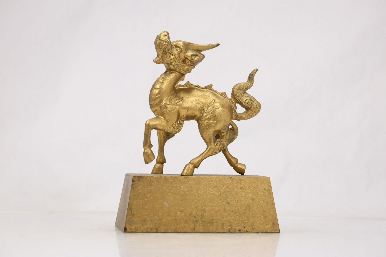 Brass Winged Mythical Creature Sculpture: Cast brass sculpture of a winged mythical animal mounted on a rectangular base. The creature combines an elongated body raised tail and detailed wings in a heraldic pose. The design relates to