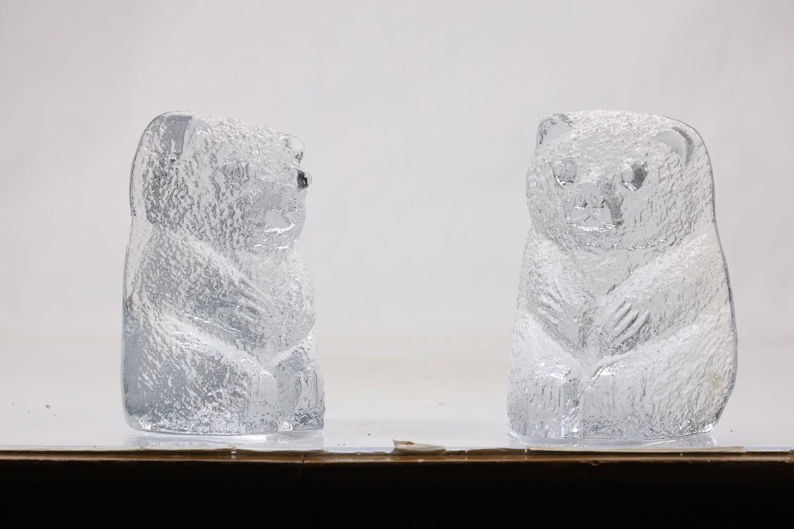 Pair Frosted Crystal Bear Figurines: Pair of clear and frosted crystal bear sculptures modeled in upright poses with cut facial and fur details. The compact figures combine polished and matte surfaces. The form relates to twentieth
