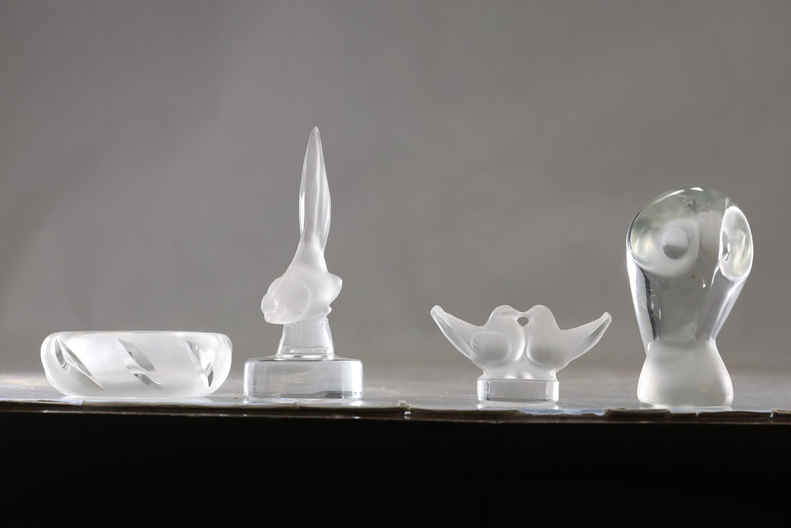 Group of Frosted Crystal Animal Miniatures: Group of small clear and frosted crystal animal figures including varied bird and mammal forms. Each miniature uses molded contours and polished surfaces for compact display. The form relates to