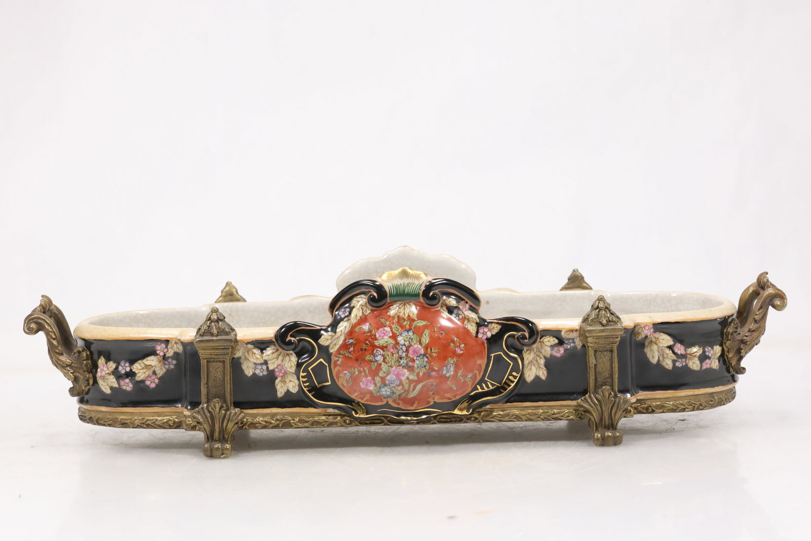 Painted Porcelain Figural Serving Tray: Long porcelain serving tray with raised end compartments and colorful hand painted figures floral motifs and gilt accents. The underside bears a red printed maker mark visible in the photographs. The