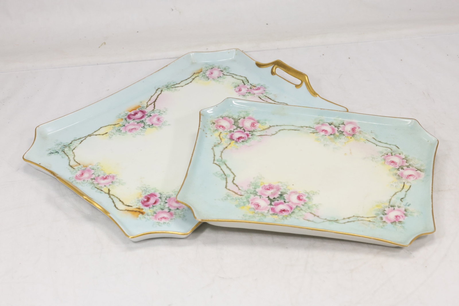 Pair Marked Porcelain Serving Trays: Pair of pale mint and white porcelain serving trays with scalloped edges delicate floral accents and gilt trim. Green printed factory marks appear on the undersides. The set relates to twentieth