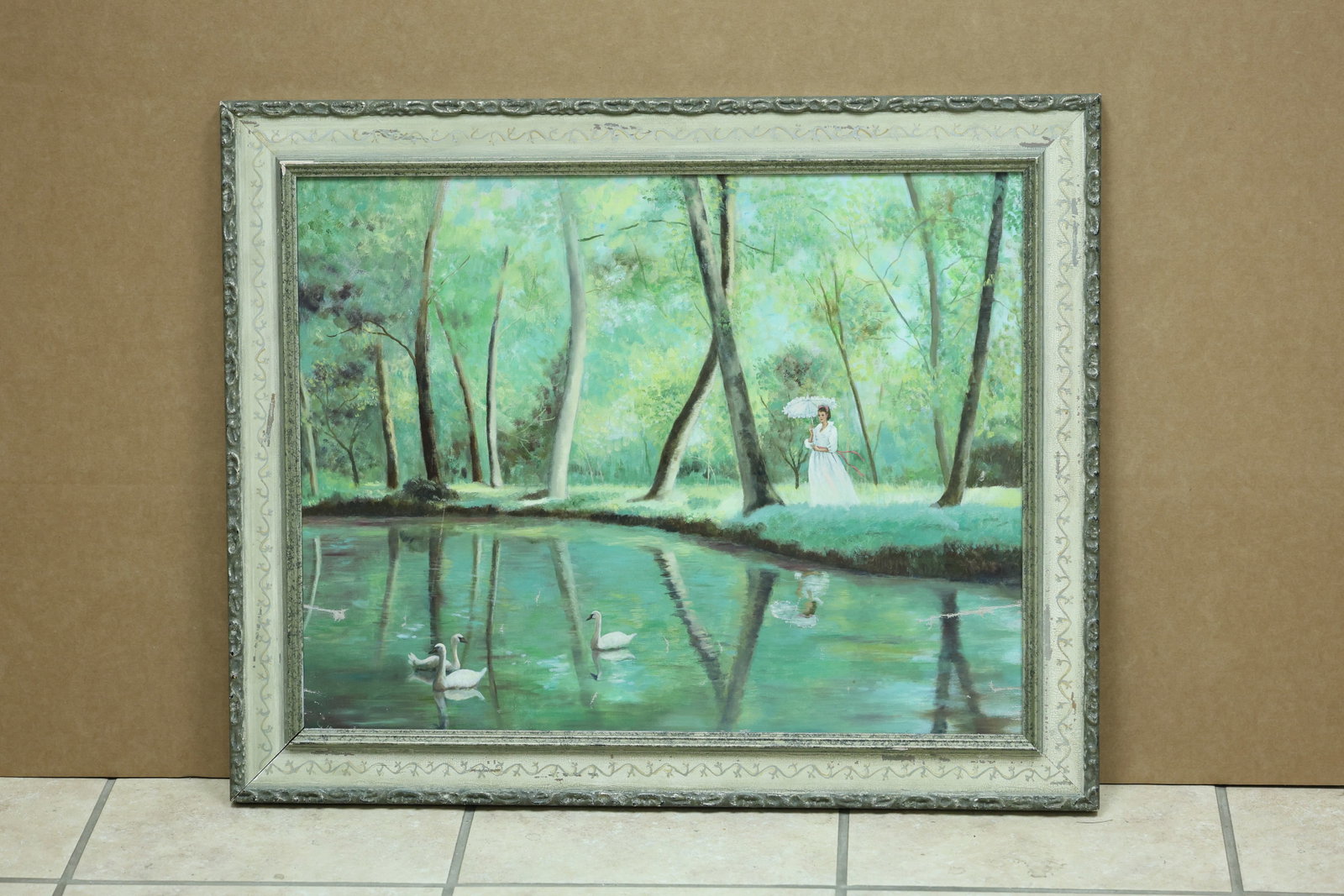 Woman with Swans in Wooded Pond Landscape Painting: Framed painting on canvas depicting a woman in a white dress and hat beside a wooded pond with two swans. The work is unmarked in the reviewed photographs. The broken color and atmospheric handling re