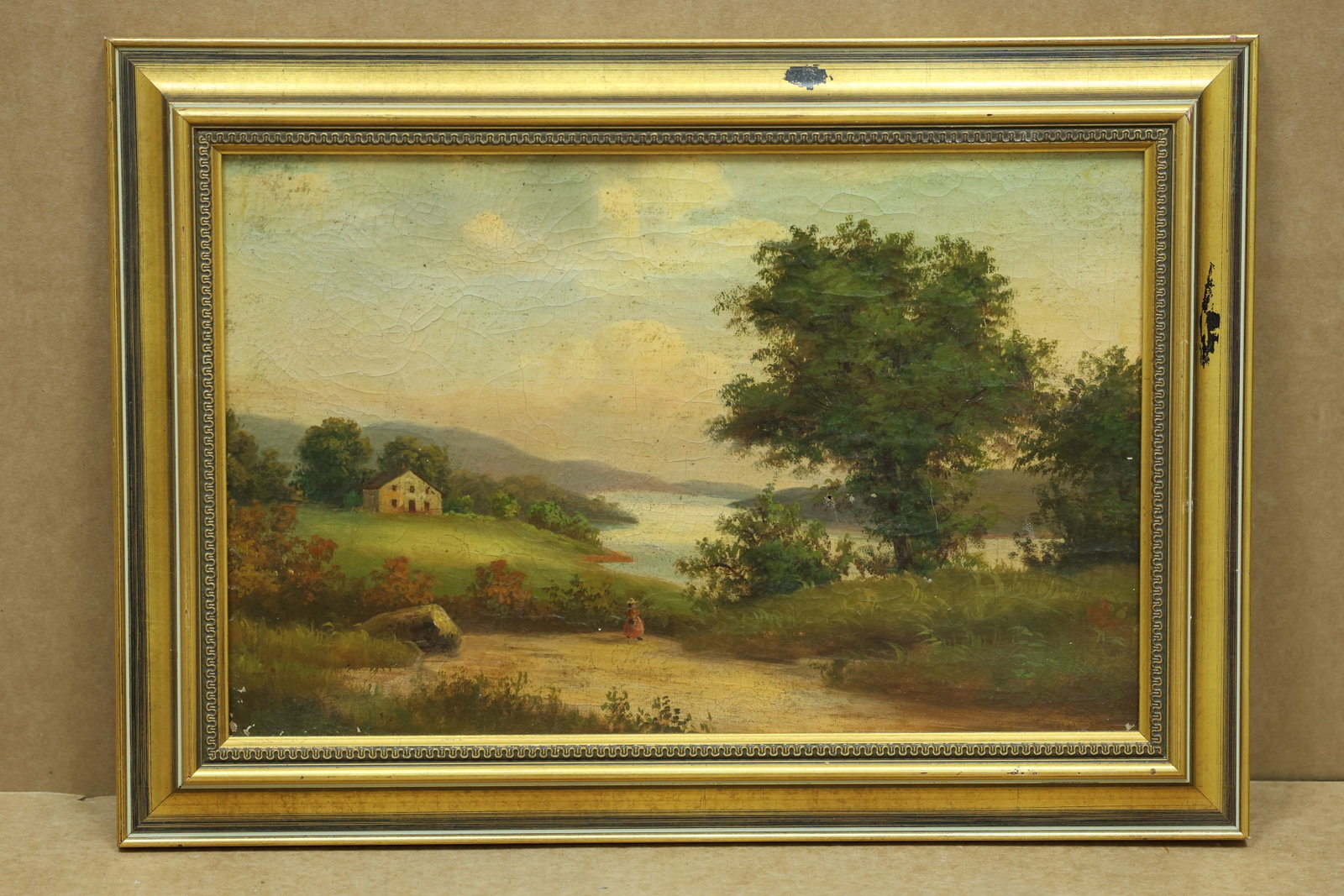 Antique Unsigned Pastoral Cottage and Lake Landscape Painting: Antique framed pastoral landscape painting depicting a cottage near a lake with a winding path trees and a small figure. No readable artist signature is visible in the reviewed photographs. The compos