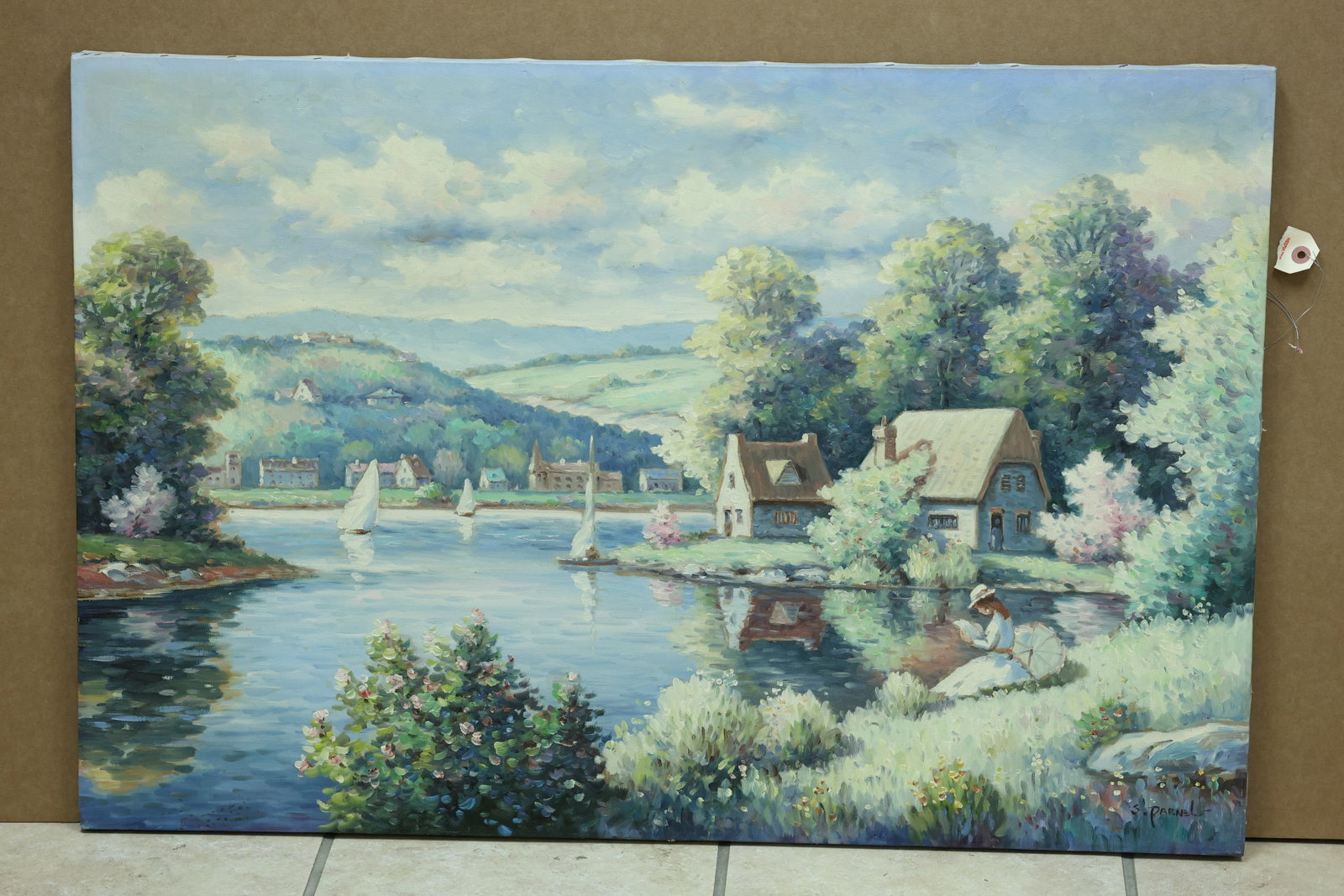 S Parnell Style Lakeside Village and Sailboats Painting: Framed landscape painting depicting a lakeside village sailboats and a seated woman in the foreground. The lower signature appears to read S Parnell but the spelling is not fully confirmed. The broken