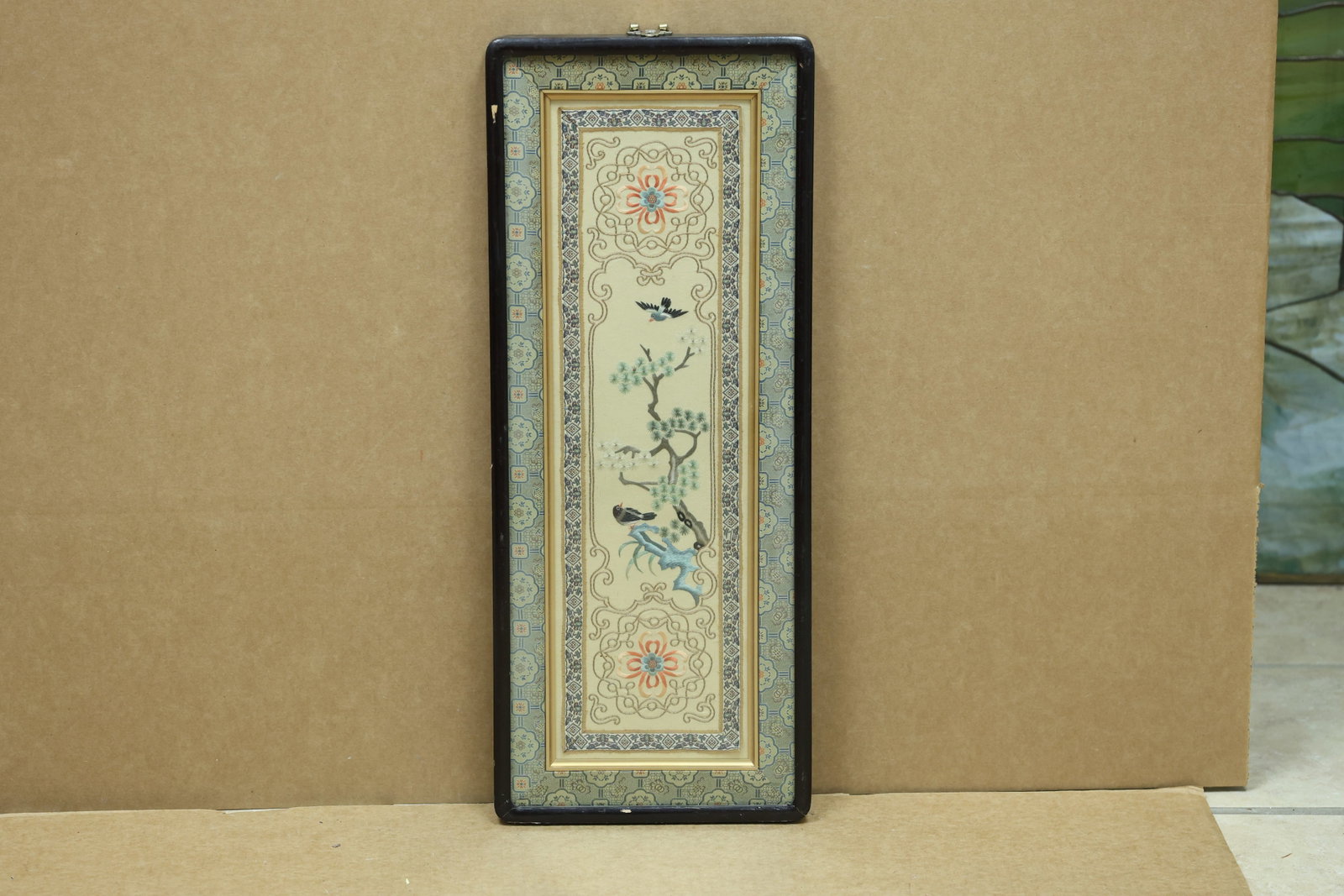 Chinese Embroidered Silk Birds Pine and Dragon Panel: Framed Chinese embroidered silk panel featuring birds pine branches floral medallions and a dragon or rock form. No readable workshop label is visible in the reviewed photographs. The stitched image r