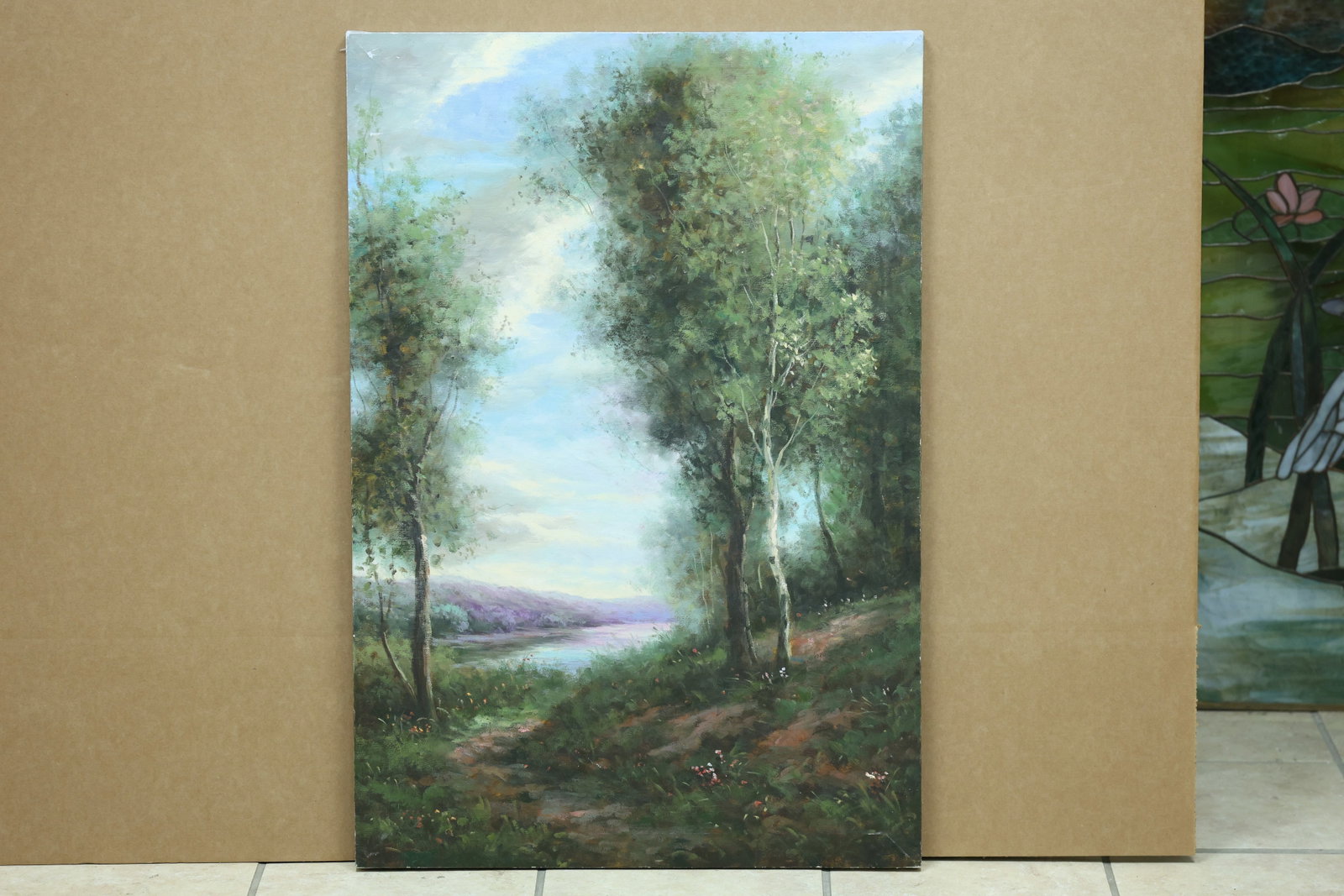 Wooded Lakeside Path Landscape Painting on Canvas: Framed landscape painting on canvas depicting a path beside a wooded lake. No readable artist signature is visible in the reviewed photographs. The composed view relates to American and European lands