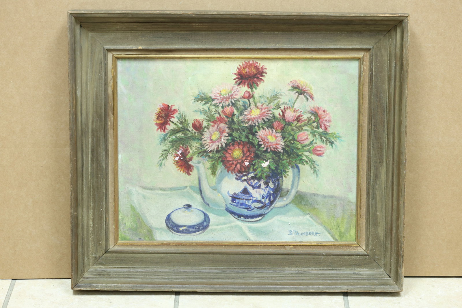 B Trumbore Flower Still Life in Blue White Pitcher: Framed floral still life painting depicting colorful flowers in a blue and white pitcher. The work is signed B Trumbore. The floral subject relates to modern still life traditions associated with Geor