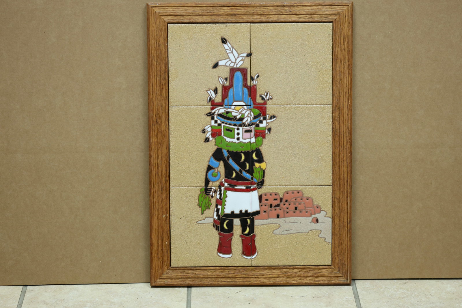 Hopi Kachina Figure Framed Ceramic Tile Panel: Framed ceramic tile panel depicting a Hopi kachina figure in geometric colors. A dealer label is attached to the reverse and no readable maker mark is visible in the reviewed photographs. The subject 