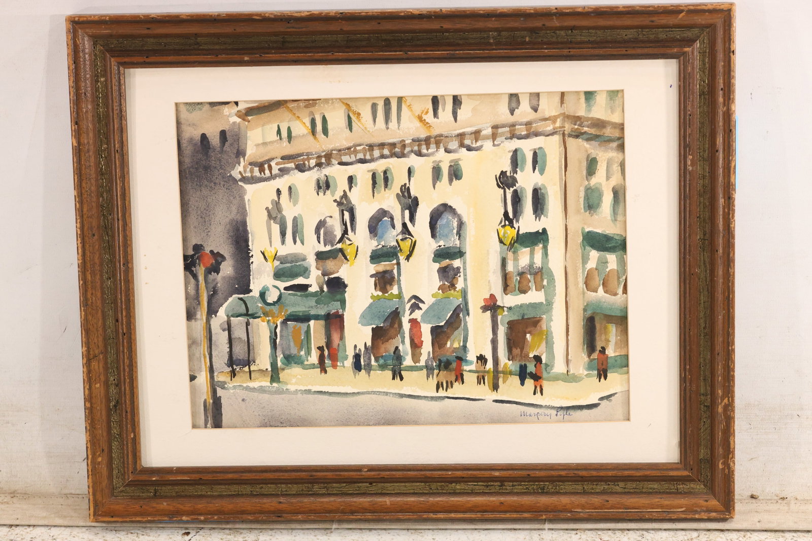 Signed Margery Pyle Modernist Street Scene Watercolor: Original watercolor on paper signed Margery Pyle. The urban street scene shows figures and building facades through loose black line and transparent washes of cream blue green and ochre. The economica