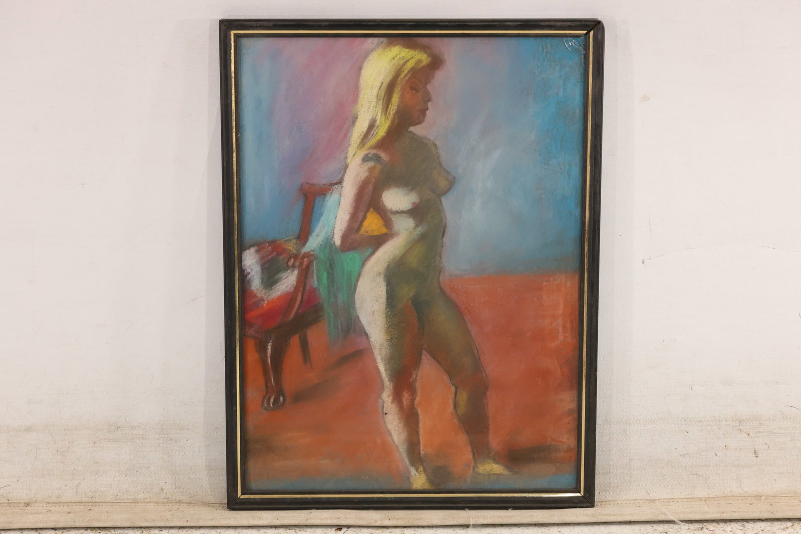 Unsigned Female Nude Pastel Drawing: Unsigned pastel drawing of a standing female nude rendered in muted red green blue and ochre. The figure is set against a softly blended interior field and presented in a simple frame. The economical 