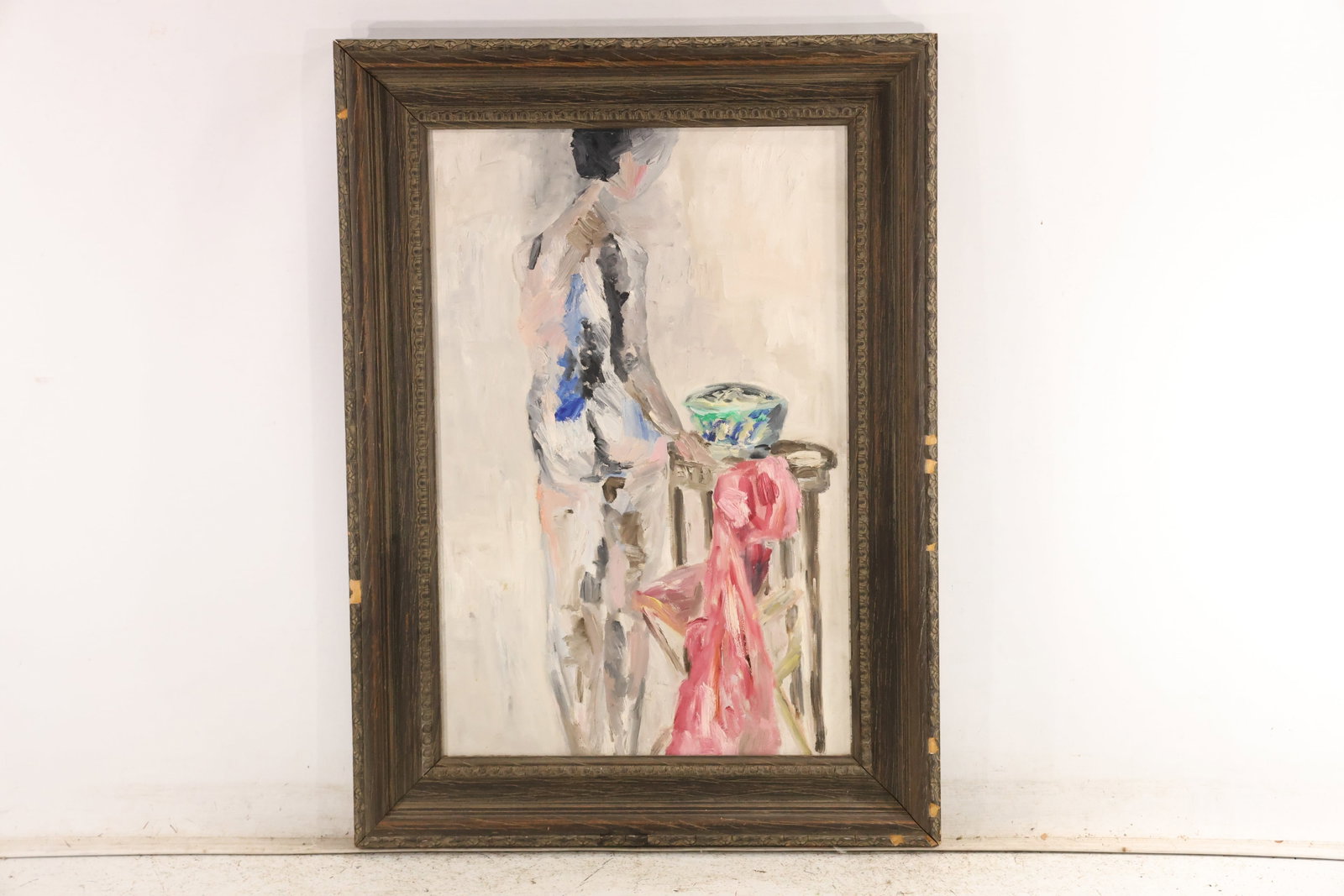 Unsigned Mid Century Woman at Table Oil Painting: Unsigned original oil painting on canvas depicting a standing woman beside a table with a bowl and draped red cloth. Pale gray blue pink and black brushwork simplifies the figure and interior. The loo