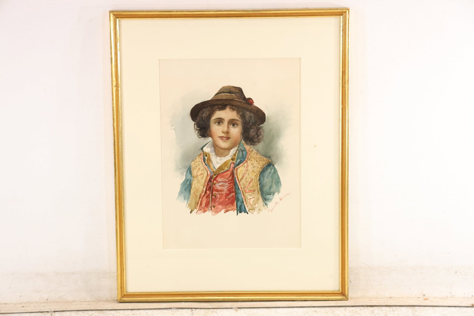 Signed Carlo Cazzaniga Roma Italian Boy Watercolor Portrait: Original watercolor portrait signed Cazzaniga Roma at the lower right. A young boy in regional dress wears a dark hat red vest patterned waistcoat and blue green coat against an open paper ground. The