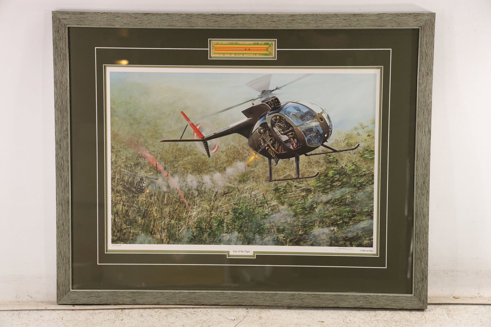 Joe Kline Eye of the Tiger Aviation Print 636 of 1000: Limited edition aviation print titled Eye of the Tiger by military artist and Vietnam veteran Joe Kline. The scene depicts a Hughes OH 6A Loach helicopter flying low over the jungle during a Vietnam W