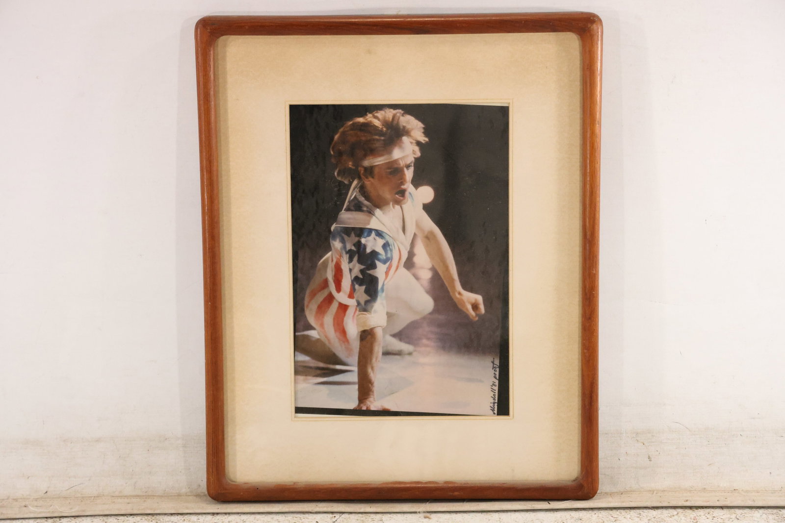 Signed “Mijdall ’81 Proof?? Theatrical Dancer Photograph: Photographic portrait of a performer wearing a stars-and-stripes costume and headband. Inscribed “Mijdall ’81 proof” at the lower right of the mat. Presented in a rounded wood frame with a