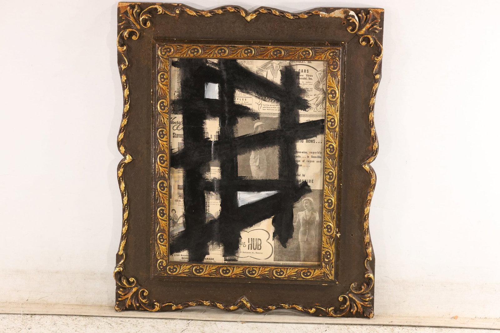 Thomas Pulgini Black Gesture Abstraction on Printed Paper Painting: Original painting by Thomas Pulgini. Broad intersecting black strokes over a pale ground with visible printed text. Presented in an ornate gold-toned frame. Size: 18 x 13.5 inches. Outside frame measu
