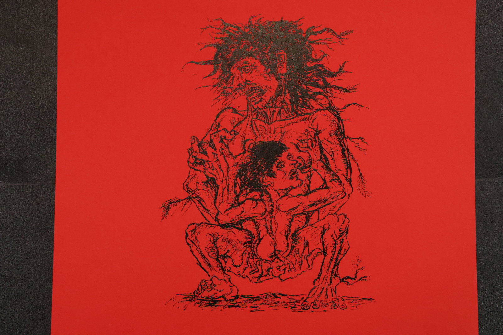 Fantastic Figure Woodblock Print on Red Paper: Black woodblock print on red paper depicting a crouching fantastic figure with wild hair, exaggerated features, and layered facial details. Size: Paper: 25 x 18 inches. Shelf ID: mc1 **Pickup Notice:*