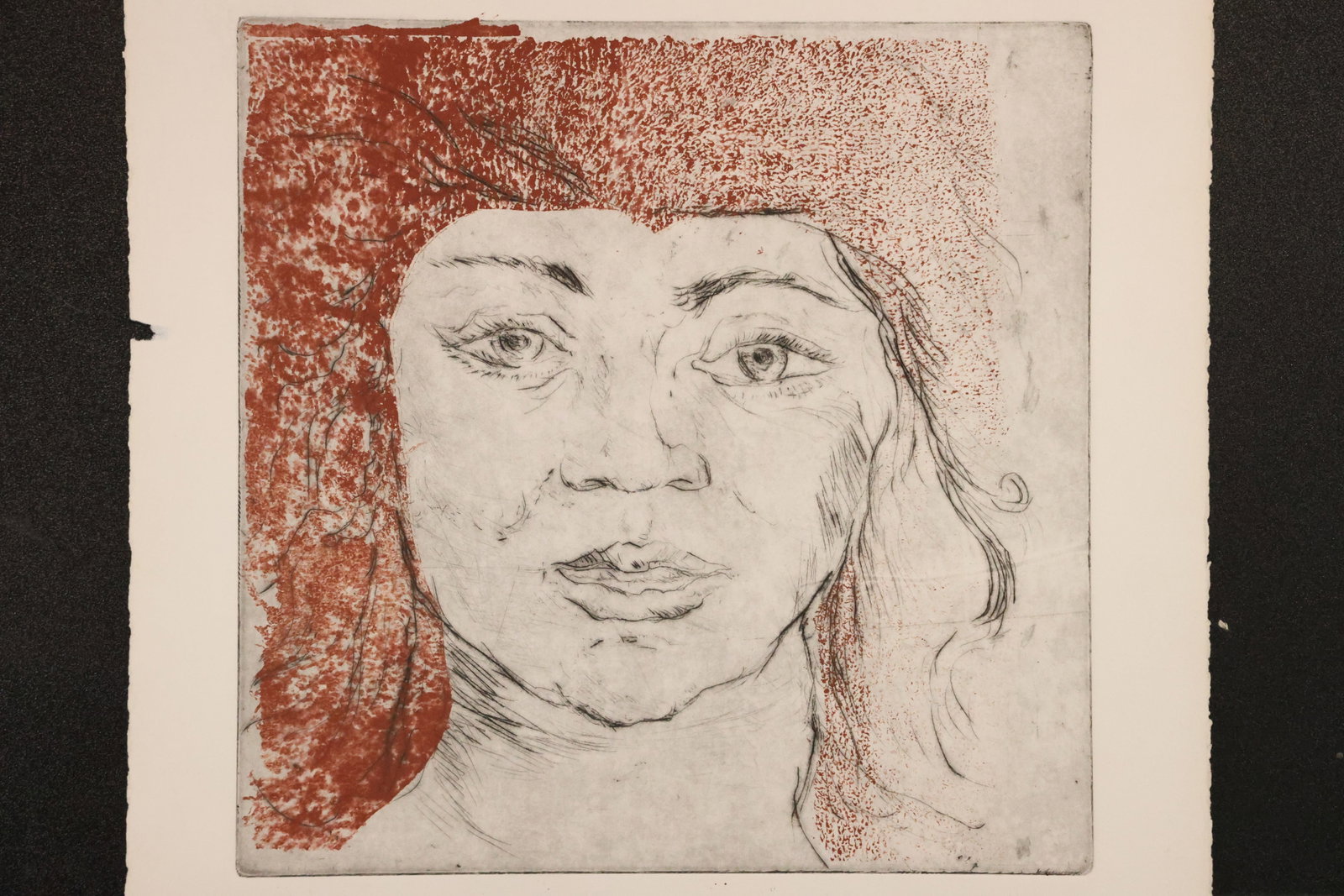 Female Portrait Print in Red and Black: Print on paper depicting a woman’s face beneath a dark red cap or head covering, rendered with fine black lines against a reddish textured background. Size: Paper: 22 x 15 inches. Shelf ID: mc2 **Pi