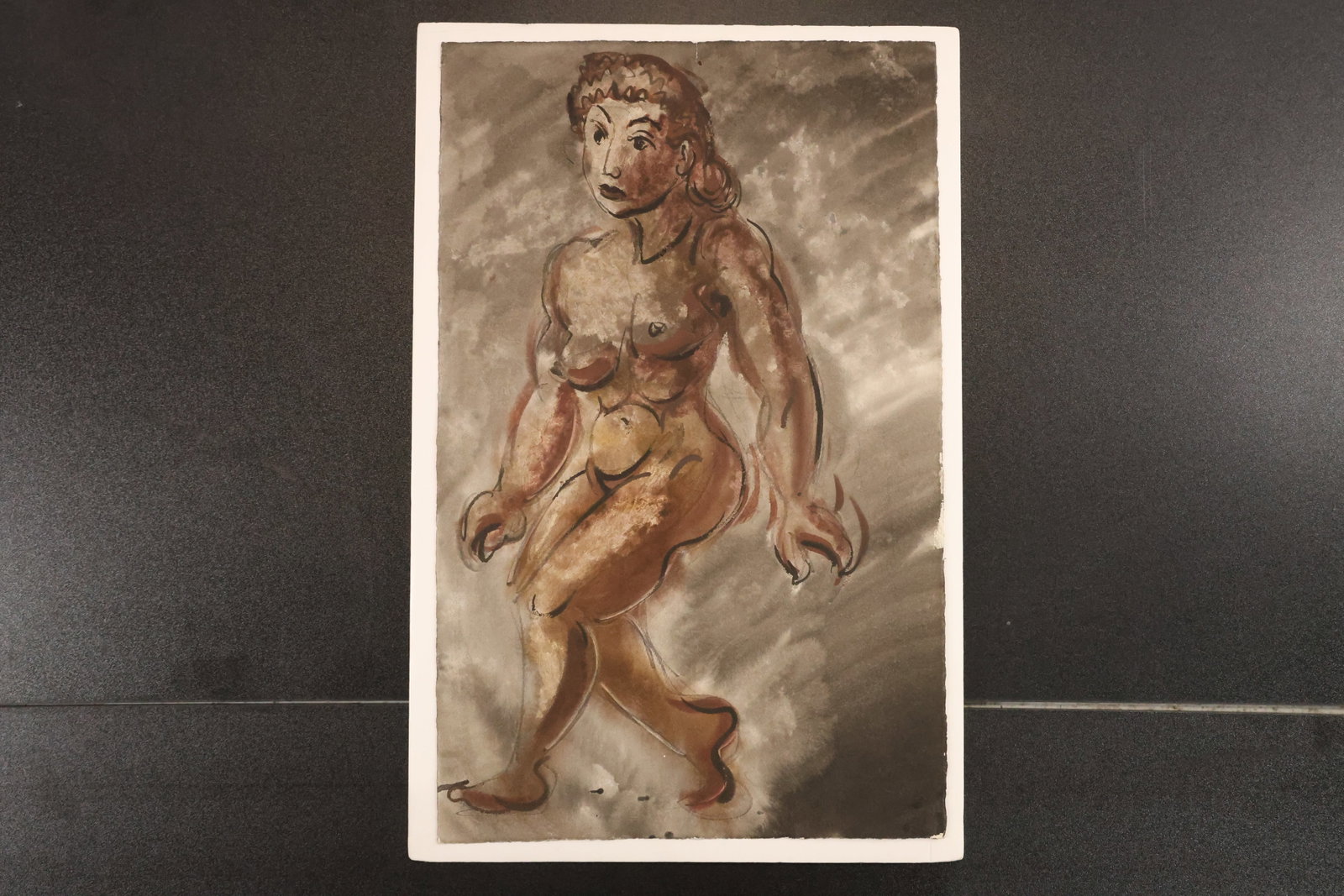 Figural Watercolor from the Estate of Jane P. Ritter: Watercolor on paper depicting a seated female figure in loose brown and gray washes. The reverse bears an Estate of Jane P. Ritter stamp, Ogunquit, Maine, dated 2004. Size: 21 x 14 inches. Shelf ID: m