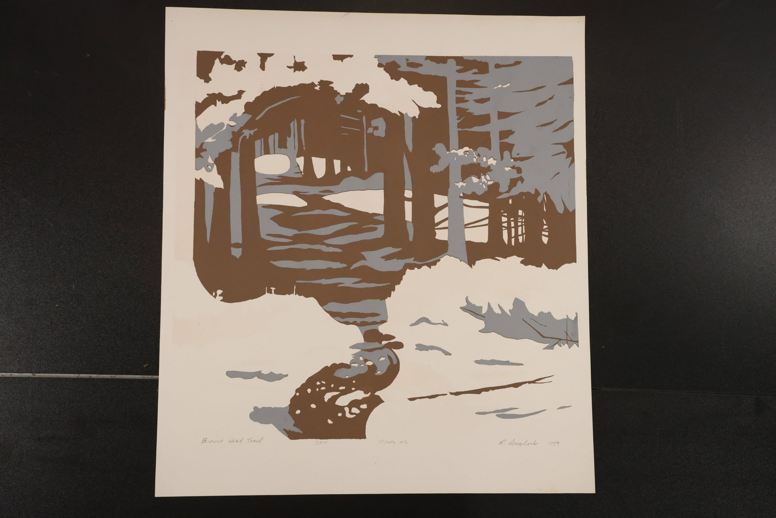 R. Angeloch Brown and Gray Woodland Color Print: A color print by R. Angeloch depicting a stream winding beneath an arch of trees. Brown and gray forms stand against a light ground. Size: 22.5 x 20 inches. Shelf ID: mc4 **Pickup Notice:** This item 