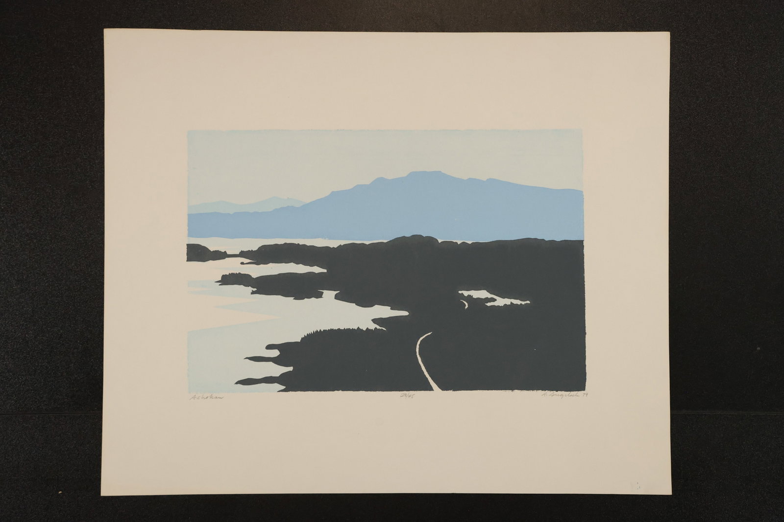 R. Angeloch Blue Mountain and Shoreline Color Print: A color print by R. Angeloch featuring a distant blue mountain above dark shoreline forms and pale water. A fine curved white line crosses the foreground. Size: 14 x 17 inches. Shelf ID: mc4 **Pickup 