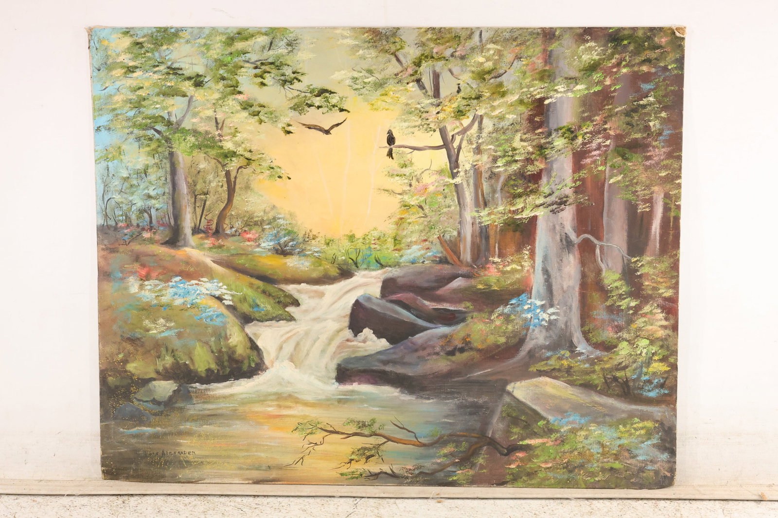 Alexander Signed Woodland Waterfall Painting: A landscape painting on board signed "Alexander" at lower left. A stream tumbles over rocks beneath tall trees, with blue flowers along the banks and a bird perched against a luminous yellow sky. Pres