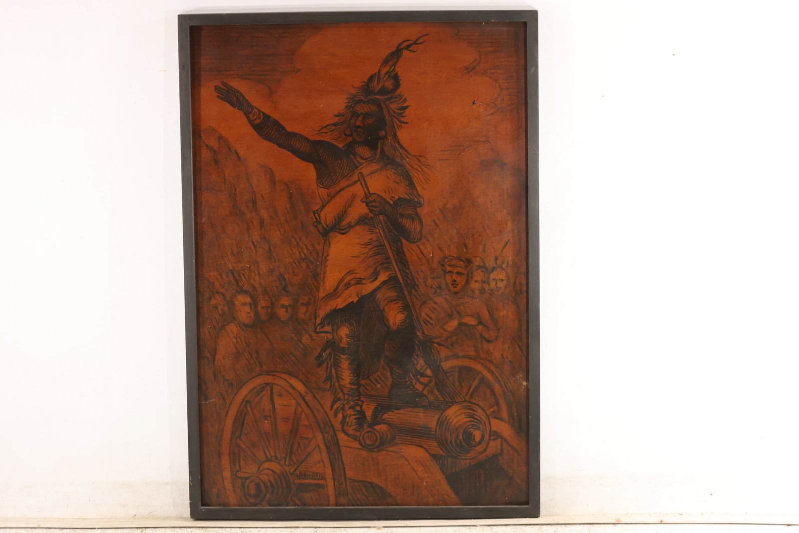 Chief Placido Frontier Scene Decorative Wood Panel: A decorative wood panel depicting Chief Placido standing above a cannon with one arm raised, with a crowd of figures behind him. Dark illustrative lines stand out against an amber-brown ground. The sc