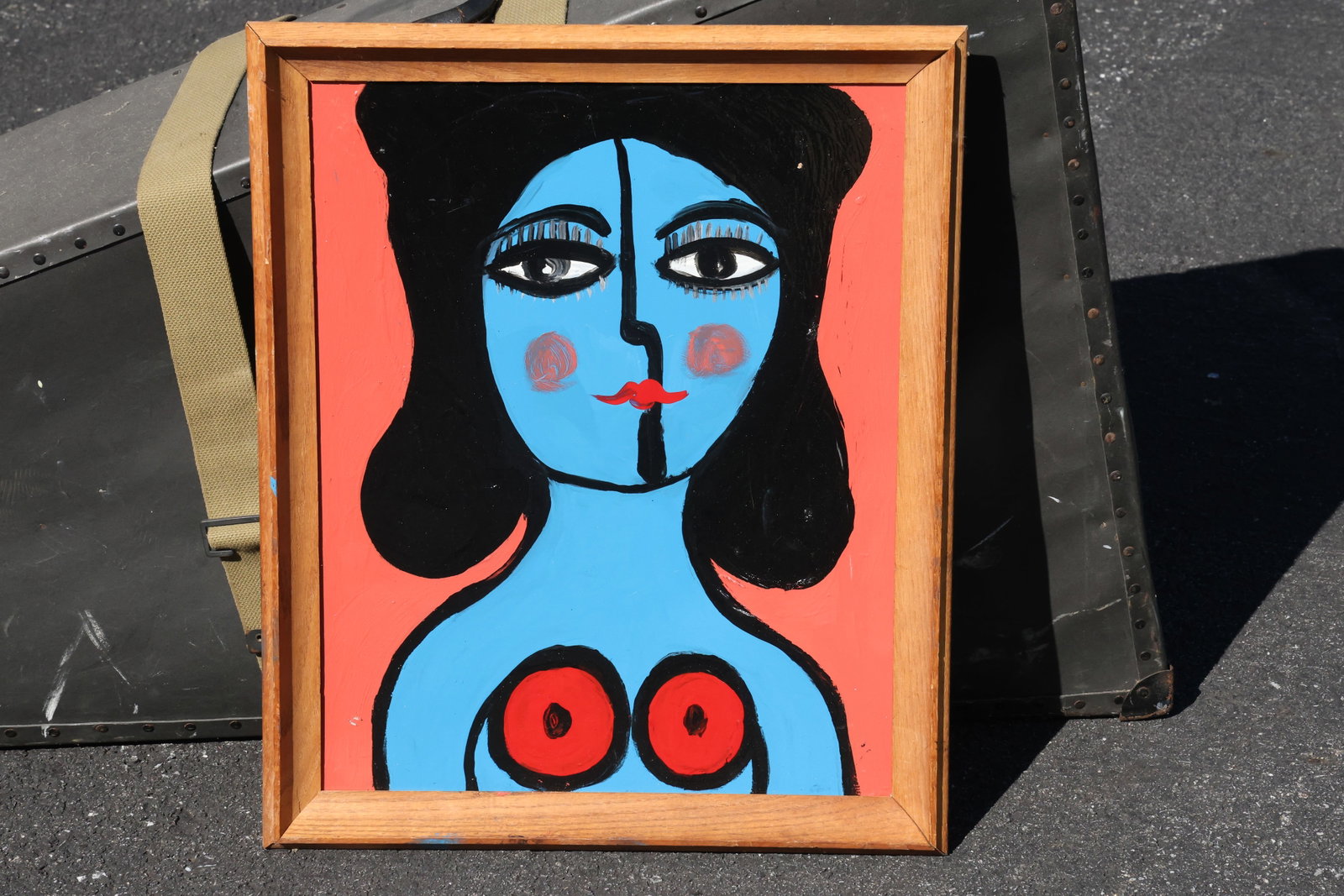 Thomas Pulgini Blue Portrait with Pink Cheeks Painting: Painting by Thomas Pulgini. A frontal blue portrait with rounded black hair, large eyes, and pink circular cheeks. Red circular chest accents contrast with the warm coral background. Size: 16 x 20 inc