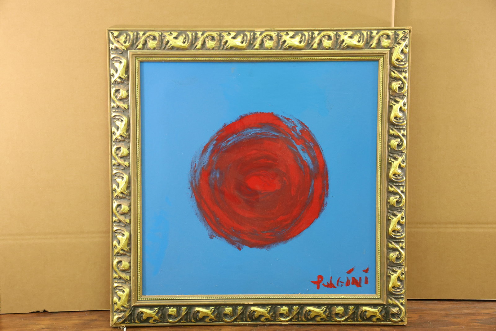Signed Pulgini Red Circle on Blue Abstract Painting: Square abstract painting with a central red circular form on a blue ground. Layered circular strokes introduce darker red and blue passages within the motif, while the surrounding field remains compar