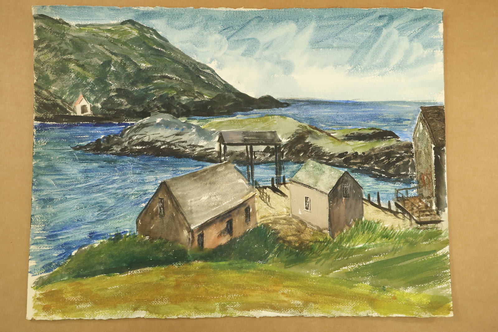 Rocky Harbor and Boathouses Watercolor Attributed to Franklin Shores: Watercolor on paper with brown and pale boathouses beside vivid blue water. A small structure on pilings stands beyond the foreground roofs, with a rocky green hillside across the inlet. Unsigned in t